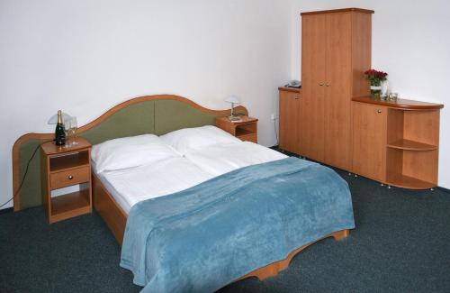 a bedroom with a bed with two night stands and two cabinets at Hotel Jaškovská Krčma in Horní Těrlicko