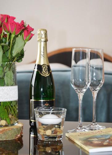 a bottle of wine and two glasses on a table at Hotel Jaškovská Krčma in Horní Těrlicko