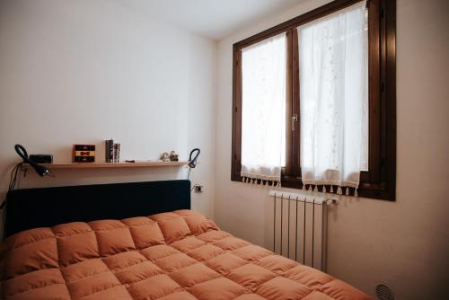 a bedroom with a bed and a window and a radiator at Val di Luce - Interno 19 in Abetone