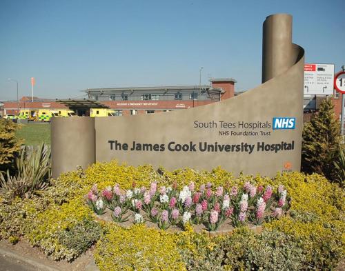 a sign for the james cook university hospital with flowers at OutRam 26 in Stockton-on-Tees