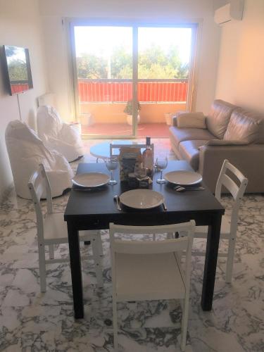un salon avec une table, des chaises et un canapé dans l'établissement Appartement de 1 à 6 personnes Beaulieu sur mer, climatisé, proche Nice et Monaco tout confort 2 chambres, à Beaulieu-sur-Mer
