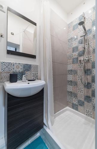 une salle de bain avec un lavabo et une douche dans l'établissement Le Little Soho, à Montpellier