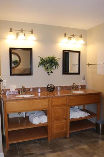 a bathroom with two sinks and two mirrors at River Crossing Resort in Pigeon Forge