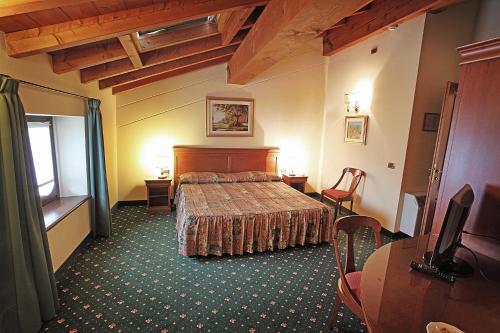 ein Hotelzimmer mit einem Bett, einem Tisch und Stühlen in der Unterkunft Hotel Faccioli in Valeggio sul Mincio