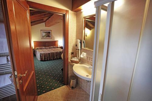 a bathroom with a sink and a bed in a room at Hotel Faccioli in Valeggio sul Mincio