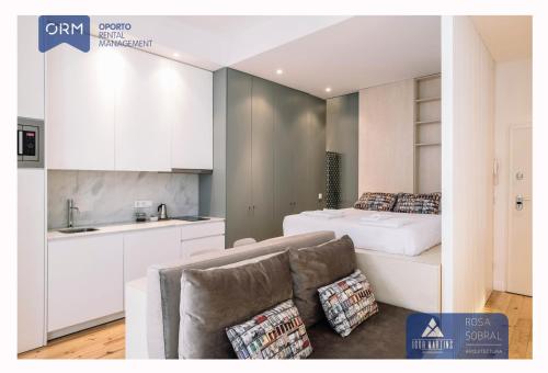 eine Küche und ein Schlafzimmer mit einem Bett und einem Sofa in der Unterkunft ORM - Mártires & Pinheiro Apartments in Porto
