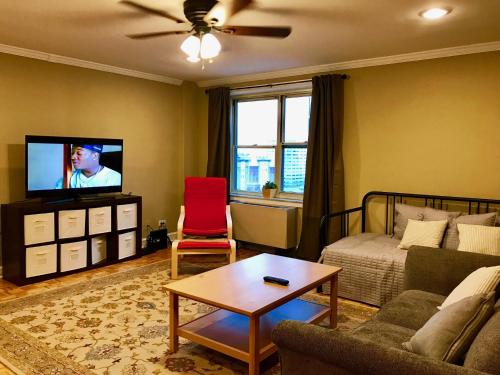 a living room with a couch and a tv at Laugh, Eat, Sleep Downtown Wine Down 9E in Atlanta