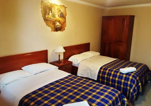 a hotel room with two beds at Posada Todos Santos in Cuenca