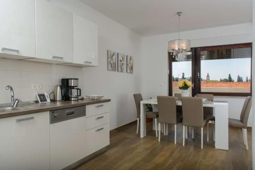 een keuken en eetkamer met een tafel en stoelen bij Ivana in Trogir