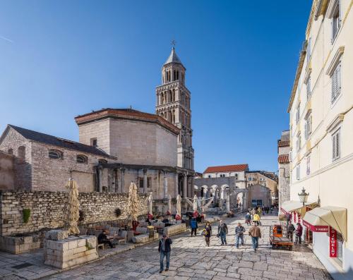 a group of people walking down a street with a tower at VIP Rooms in Split