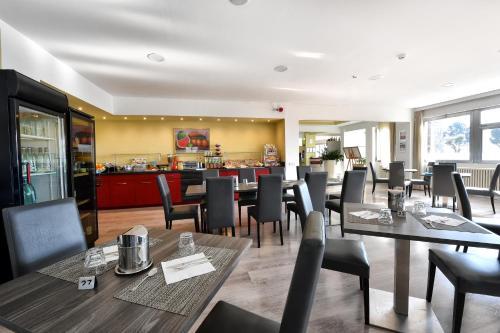 un ristorante con tavoli e sedie e un bar di Hotel Motel Europa a Domodossola