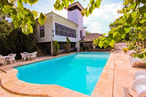 una piscina frente a una casa en Hotel Solar das Águas Cantantes, en Ubatuba