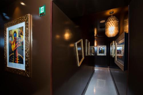 a hallway with framed pictures on the walls at Torre Argentina Relais - Residenze di Charme in Rome