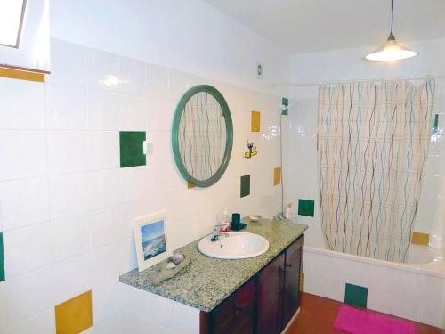 a bathroom with a sink and a mirror and a tub at PEDRA DOS CORVOS Beach House in Odeceixe