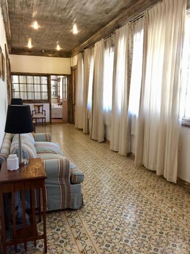 a living room with a bed and a table and windows at Hotel Casa Silva in San Fernando