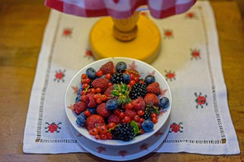 a bowl of strawberries and blueberries on a table at Holiday House Sobol in Kuželj