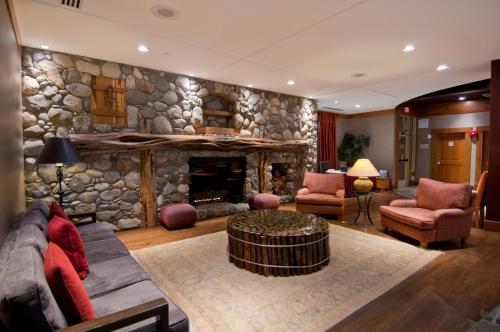 a living room with a stone wall with a fireplace at Legends in Whistler