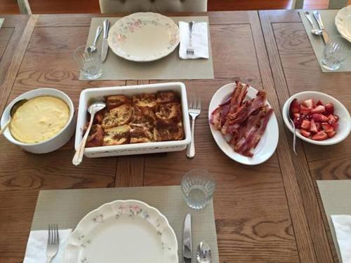 a wooden table with dishes of food on it at Katy House Bed and Breakfast in Smithville