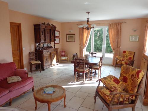 un salon avec une table et des chaises dans l'établissement B&B Les Cistelles, à Saint-Nicolas-lès-Cîteaux