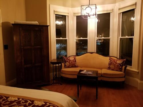 a living room with a couch and two windows at Blackberry Inn in Camden