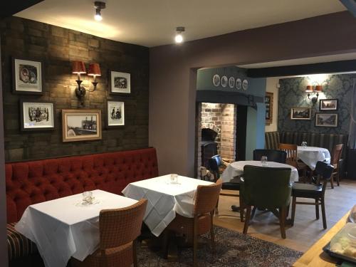a dining room with tables and chairs and a fireplace at The Angel Inn Stourport in Stourport