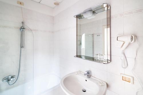 a white bathroom with a sink and a shower at Hotel St. James in Florence