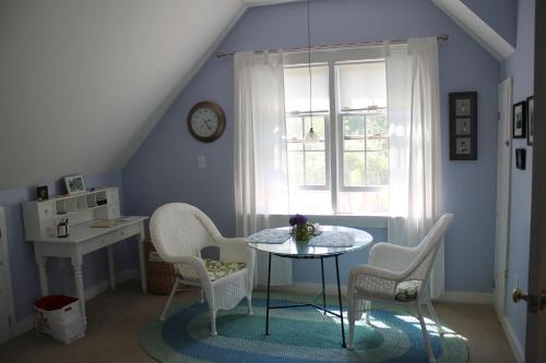 - une table et des chaises dans une chambre avec fenêtre dans l'établissement Lavender Bay, à Barnstable