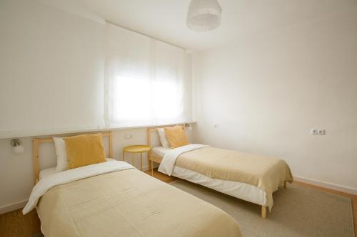 dwa łóżka w pokoju z oknem w obiekcie Miro w mieście El Campello