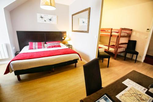 a bedroom with a large bed with a red blanket at Hôtel Le Bayeux in Bayeux