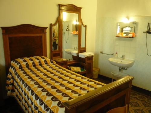 a bedroom with a bed and a sink and a mirror at Pensione Rinascente in Pisa