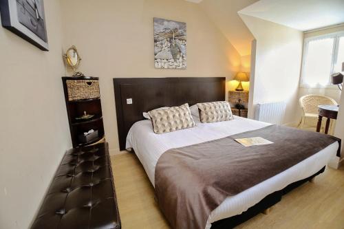 a bedroom with a large bed in a room at Hôtel Le Bayeux in Bayeux