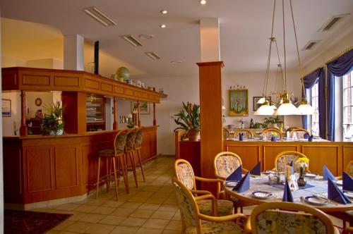 un restaurante con mesas y sillas y un bar en Hotel Park Eckersbach, en Zwickau