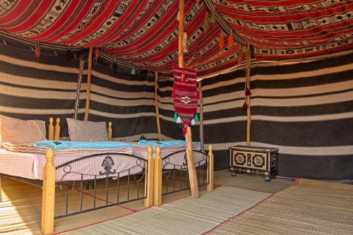a bedroom with a bed in a tent at Desert Retreat Camp in Al Wāşil