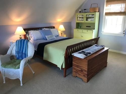 1 dormitorio con 1 cama, 1 silla y 1 mesa en Lavender Bay en Barnstable