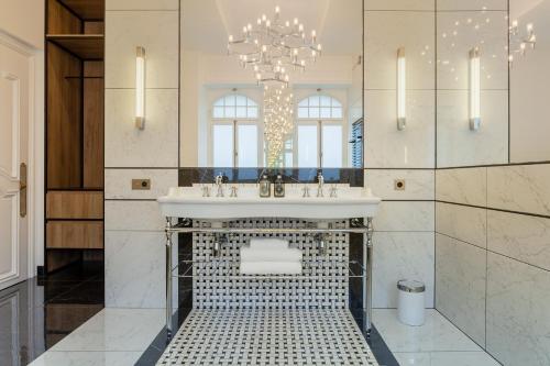 a bathroom with a sink and a chandelier at Villa Camoufle in Metz