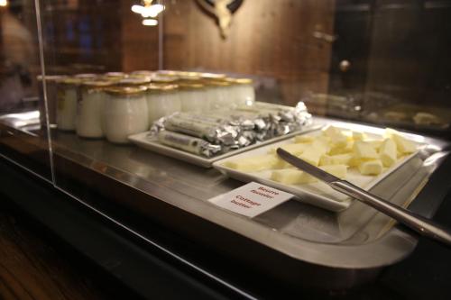 a buffet with cheese and other food on a counter at M de Megève in Megève