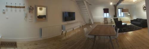 une chambre avec une table et des chaises ainsi qu'un salon dans l'établissement Loft Zola, à Dijon