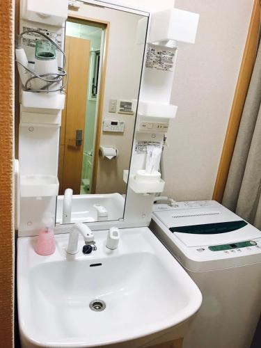 a bathroom with a white sink and a mirror at Mori de house in kobe 4 in Kobe