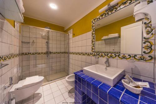 a bathroom with a sink and a toilet and a mirror at Hotel Casale Milocca in Syracuse