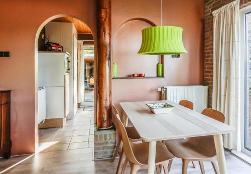 uma cozinha com uma mesa e cadeiras e um candeeiro verde em Engelbarn em Engelbert