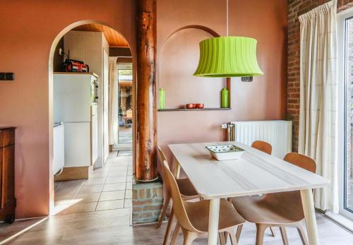 a kitchen with a table and chairs and a green lamp at Engelbarn in Engelbert