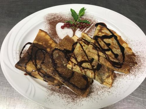 a white plate with a dessert with chocolate on it at Agriturismo Pirara in Gerocarne