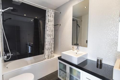 a white bathroom with a sink and a bath tub at modern flat in Estoril