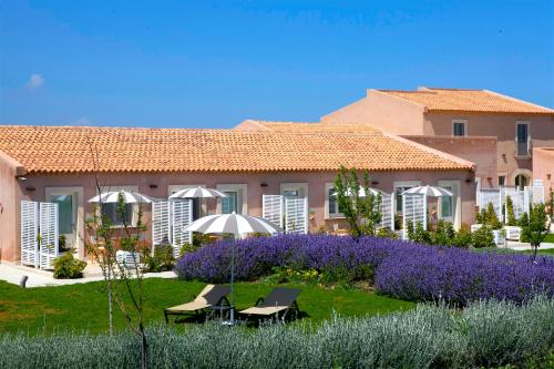 a villa with a garden in front of a building at Hotel Casale Milocca in Syracuse