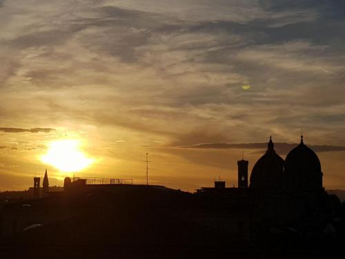 a silhouette of a city with the sunset in the background at Forte16 View & SPA in Florence
