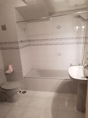 La salle de bains est pourvue d'une baignoire, de toilettes et d'un lavabo. dans l'établissement Mikes Beach Apartment, à Torreira