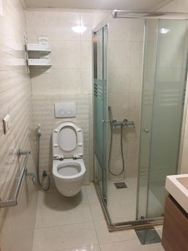 a bathroom with a toilet and a glass shower at Divan Hotel Apartments in Beirut