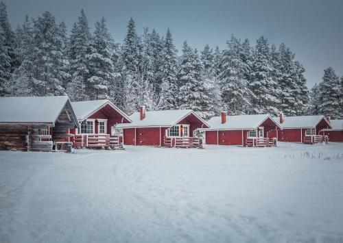 a red and white cabin in the snow at Korvala log cabins in Korvala