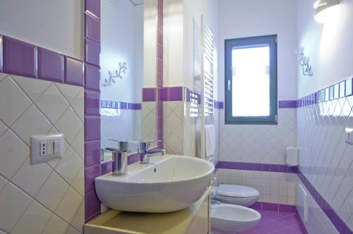 a bathroom with a sink and two toilets at L'Orso e L'Ape B&B in Giulianova