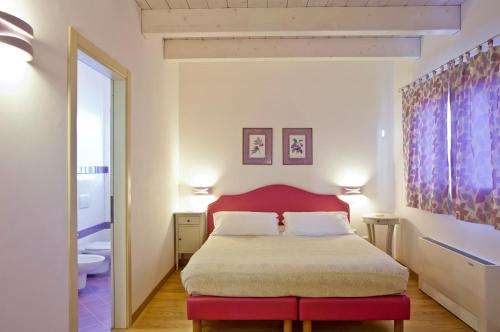 a bedroom with a large bed with a red headboard at L'Orso e L'Ape B&B in Giulianova